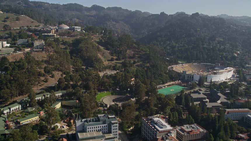 Aerial scenery of an urban city built on hills and mountains on a clear blue sky day