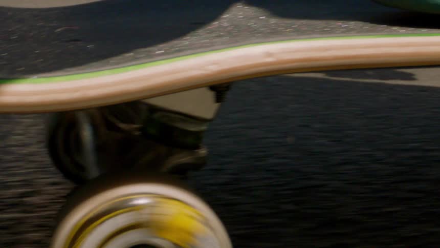 Extreme closeup of a persons foot skateboarding on the asphalt