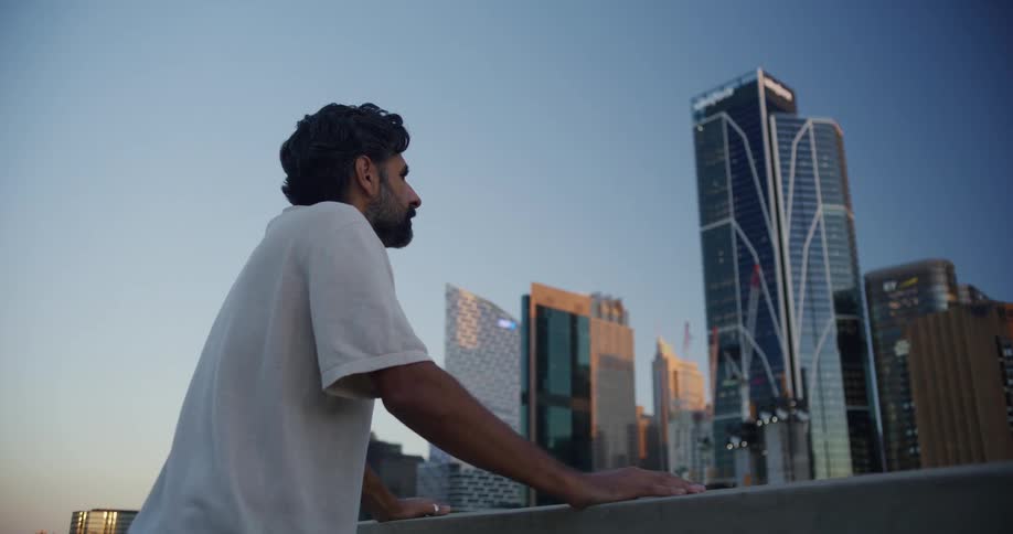 A man looks around staring at a city downtown area