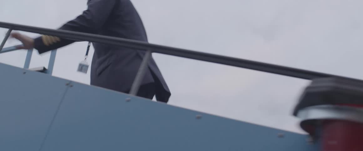 A pilot climbs stairs to a plane