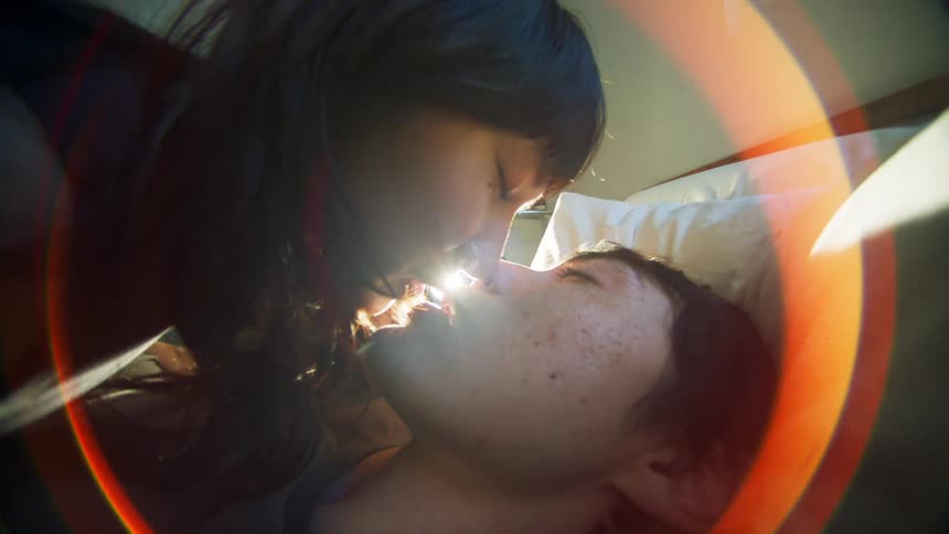 Couple kissing lying in bed
