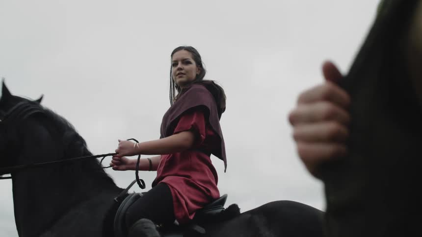 A woman on horse speaks to a man walking beside her