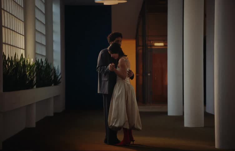 Loving couple wearing formal clothes hugging in the lobby of a building