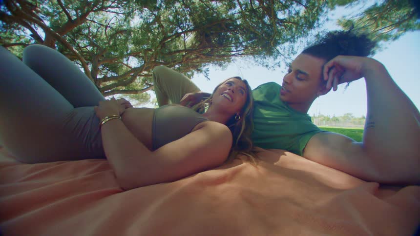 Young couple resting over a blanket in a park