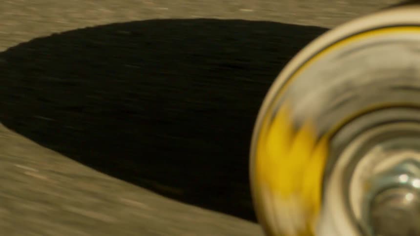 Close up of the wheels of a skateboard spinning on asphalt