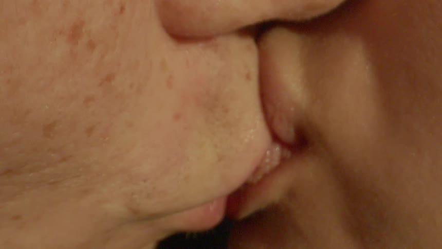 Extreme closeup of a kissing couples mouth