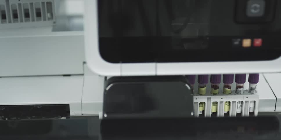 Laboratory equipment with test tubes in a row and screen with buttons