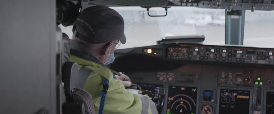 An employee walks into a cockpit and ties something to a machine