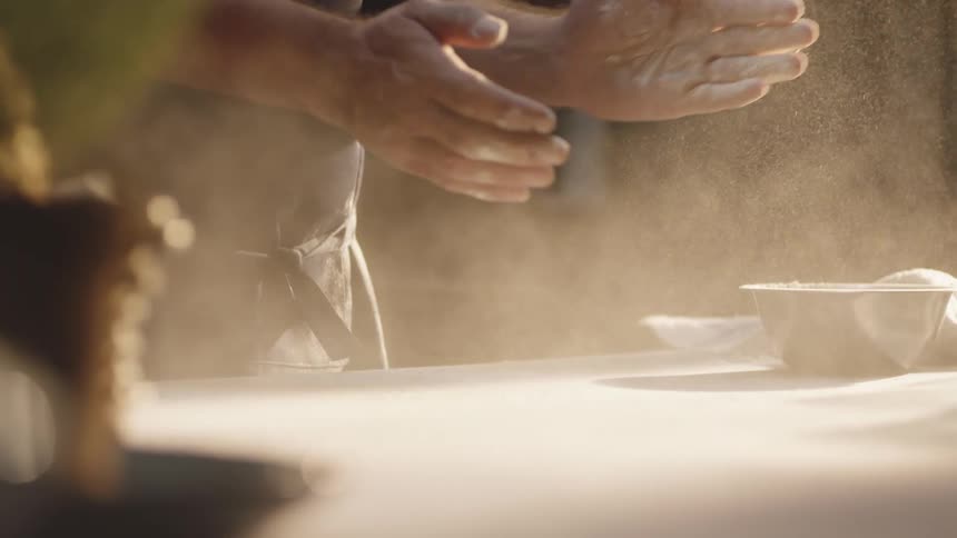 Hands of a person throwing flour on their hands and clapping