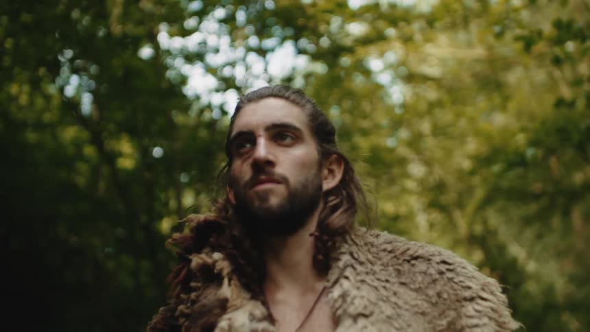 Portrait of a viking man walking through the forest with a serious facial expression