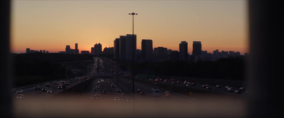 Multiple lanes of traffic filled with vehicles outside of a city