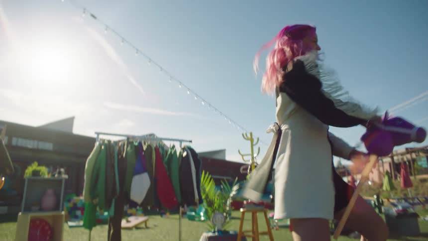 A young woman models clothing outside of a retail store