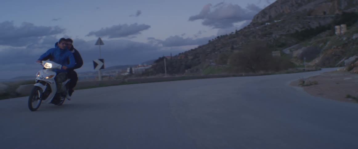 Motorcyclists ride down a rural road