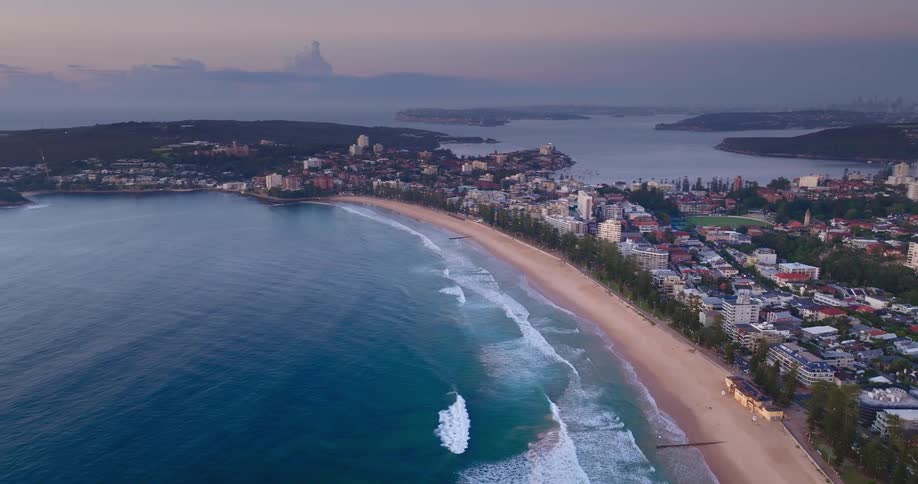 Aerial view of a coastal town with buildings near the beach at sunset