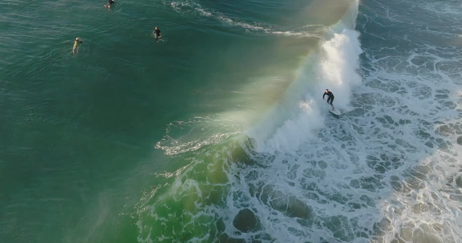 Aerial view of a group of surfers catching large waves