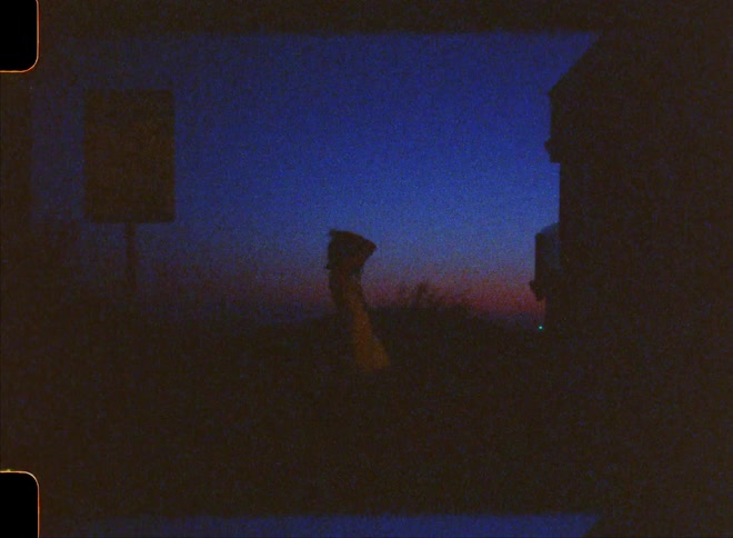 Silhouette of a woman dancing in an outdoor environment with the dark dusk sky