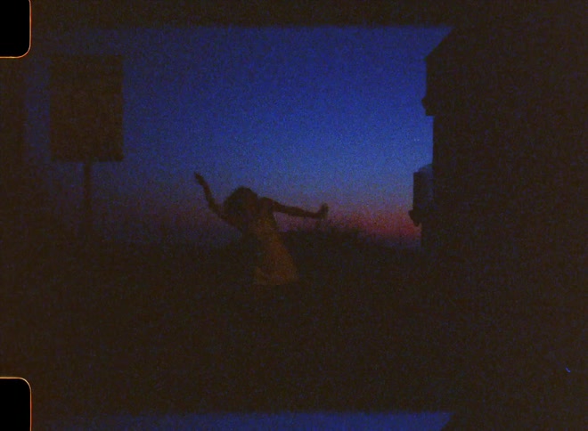 Silhouette of a woman dancing in an outdoor setting with a dark blue sky