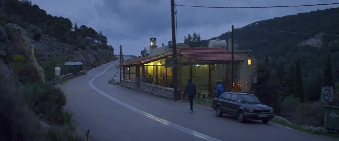 Two people exit car and head towards building