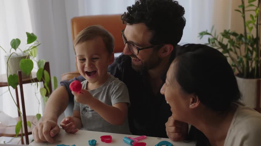 Parents play with their son at home