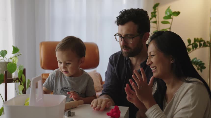 Family plays with playdo while sitting in living room