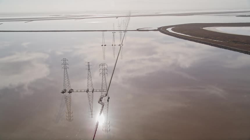 Utility lines and towers stretch over water