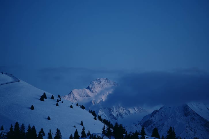Clouds float on the snow covered mountain