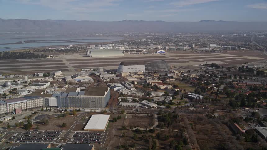 Aerial panorama of a residential neighborhood urban and commercial buildings and lakes and mountains in the background