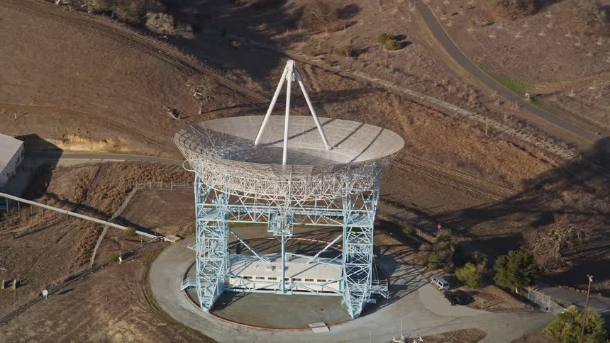 A large satellite dish is pointed towards the sky
