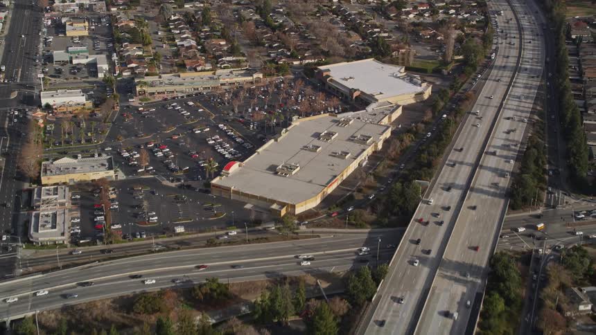 Aerial panorama of a highway with vehicle traffic passing through urban cities during the day