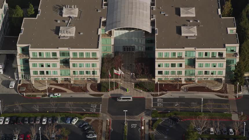 Vehicles drive past the apartment complex