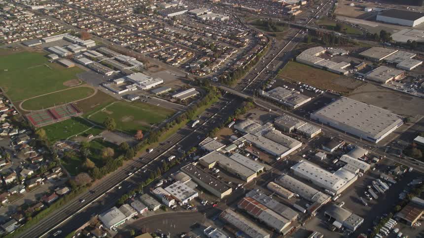 Aerial panorama of urban and industrial areas with highway intersection with vehicle traffic