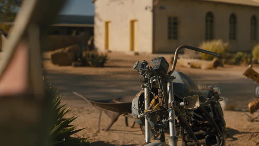 Rusty and broken motorcycle in an open environment next to a street