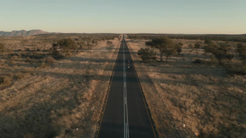 People are riding their bicycles down the empty highway