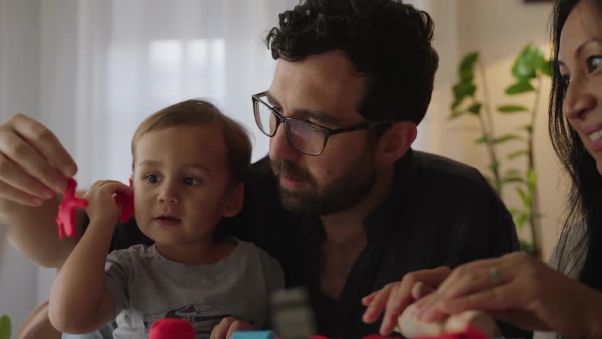 Parents play with toys with their son