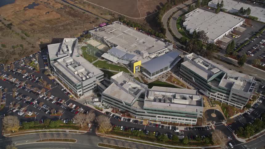 An aerial view of a complex of identical buildings and a large parking lot in front