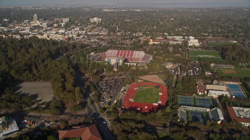 Aerial panorama of an urban city with sports stadiums around and trees