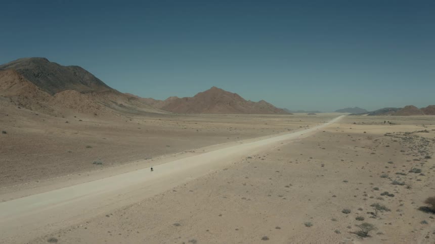 A person rides their bike in the desert