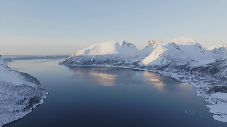 Snow covered mountains sit next to a river