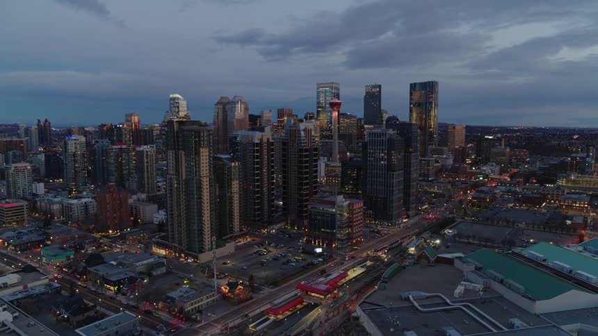 Establishing aerial dolly into city at dawn or dusk with traffic below