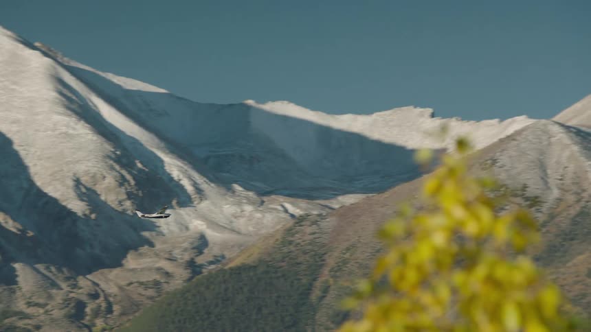 Airplane flying near mountains during clear sky day