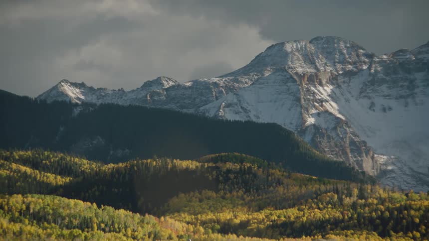 A panoramic view of a mountain range with peaks partially covered in snow