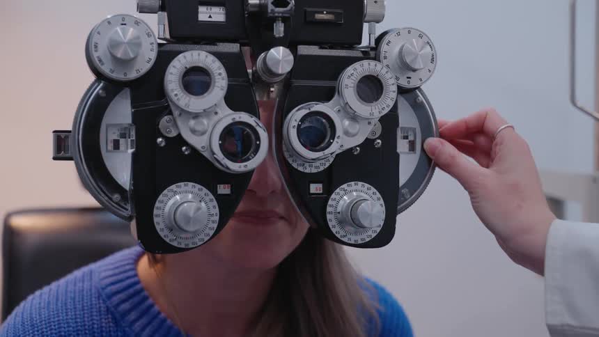 Optometrist adjusts settings on the phoropter as the patient talks