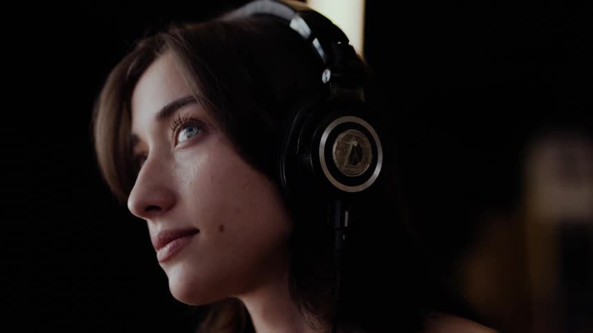 A young woman listens to headphones