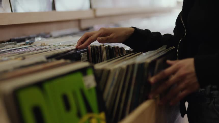 A person browsing through a collection of vinyl records on a store