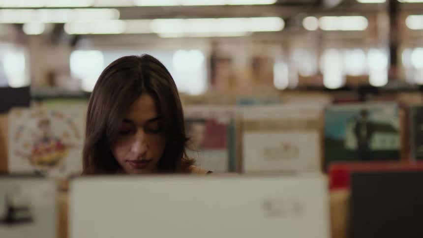 A woman browsing vinyl records at a store