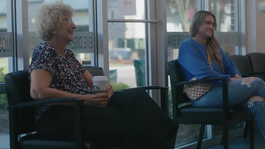 Woman and a lady sitting on chairs in a clinic talking
