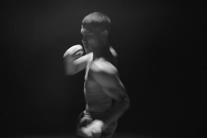 Shirtless man training boxing moves