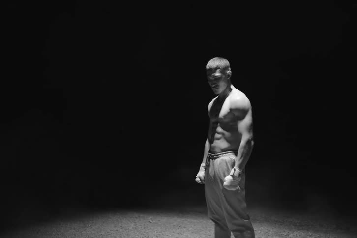 Shirtless boxer man with lights illuminated by a soft light on a black background
