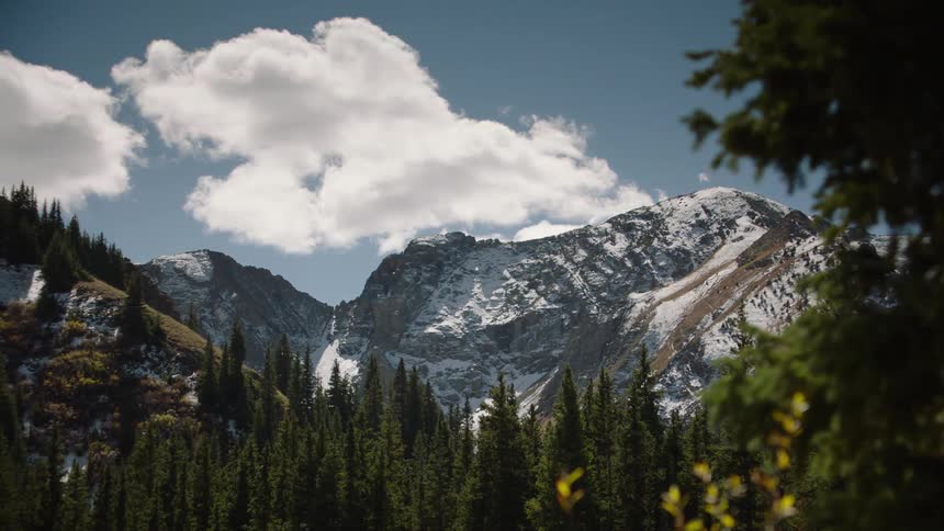 A mountain range covered in snow under a blue sky