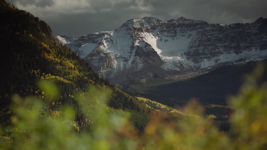 Greenish forested mountain ranges with snowy cliffs